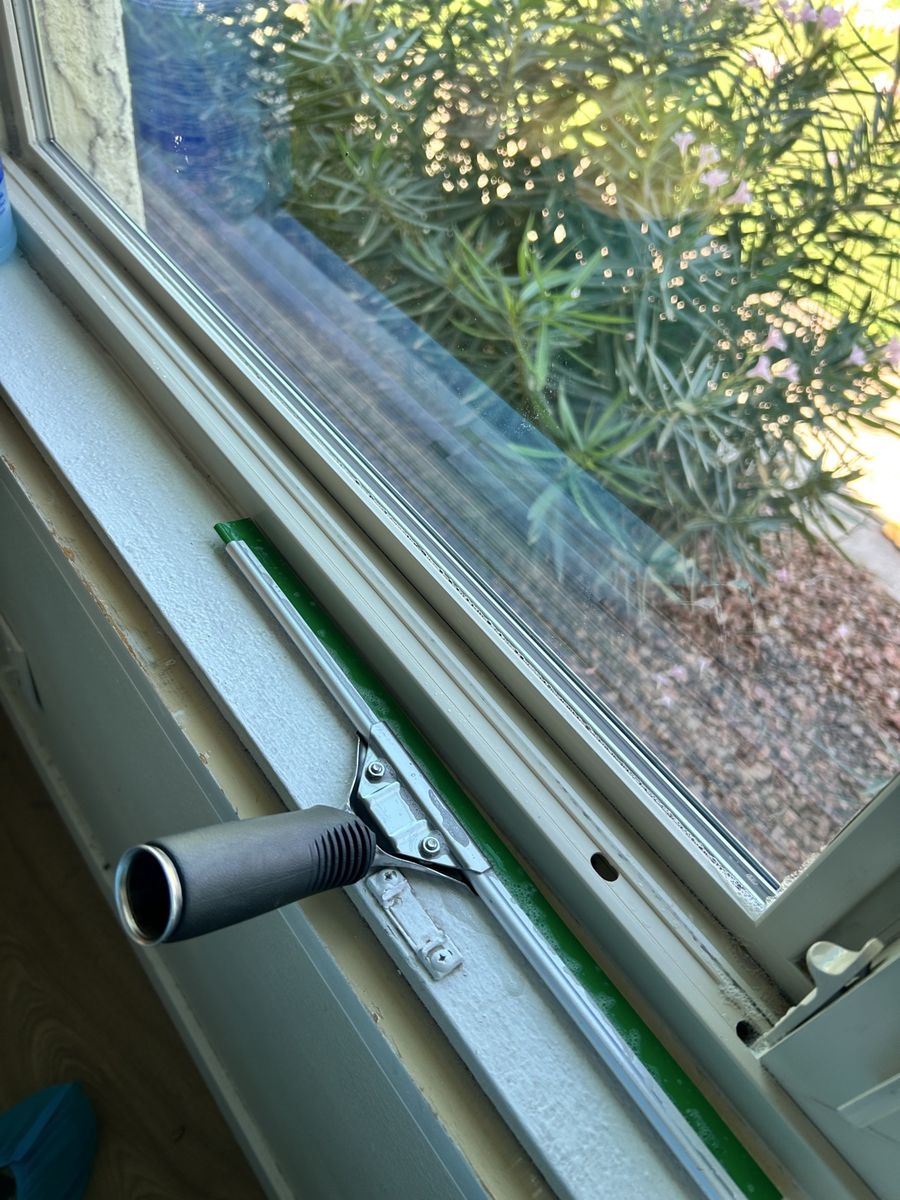 Squeegee cleaning a residential window track in Phoenix AZ